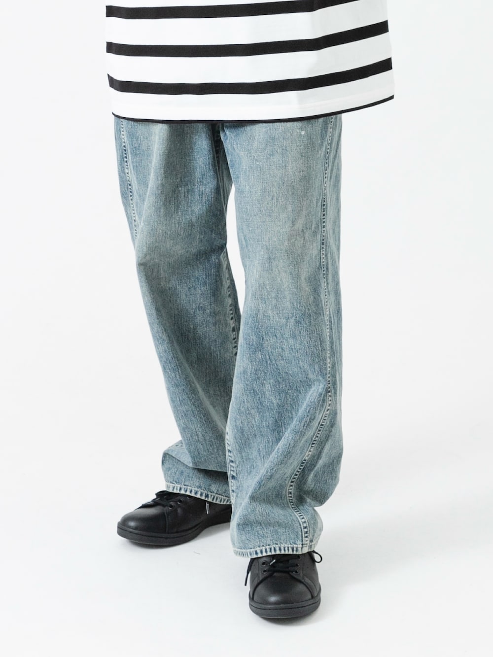 ブラック系のスニーカー、ホワイト系のTシャツ/カットソー、ブルー系のデニムパンツを着用したメンズの夏コーディネートの3枚目の写真