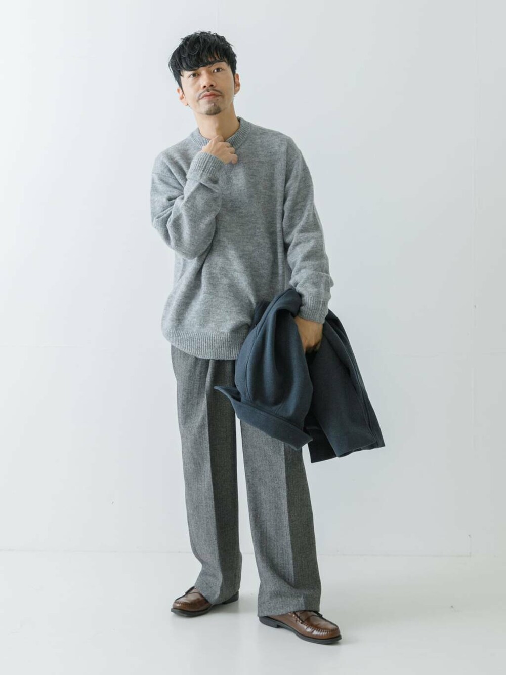 ブルー系のステンカラーコート、グレー系のニット/セーター、グレー系のスラックスを着用したメンズの冬コーディネートの3枚目の写真