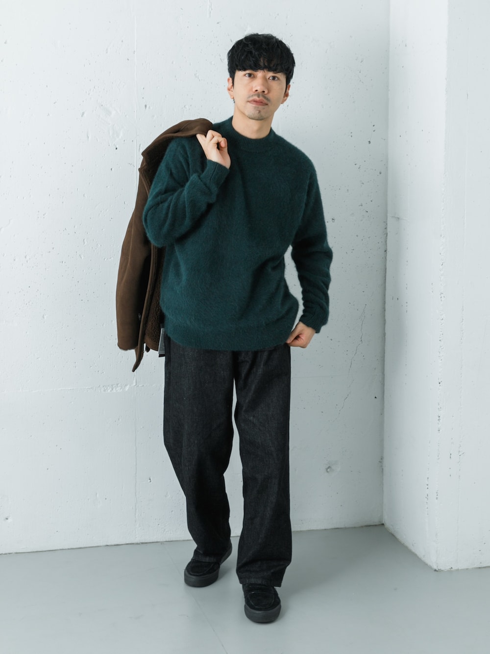 ブラック系のデニムパンツ、ブラウン系のテーラードジャケット、グリーン系のニット/セーターを着用したメンズの秋コーディネートの7枚目の写真