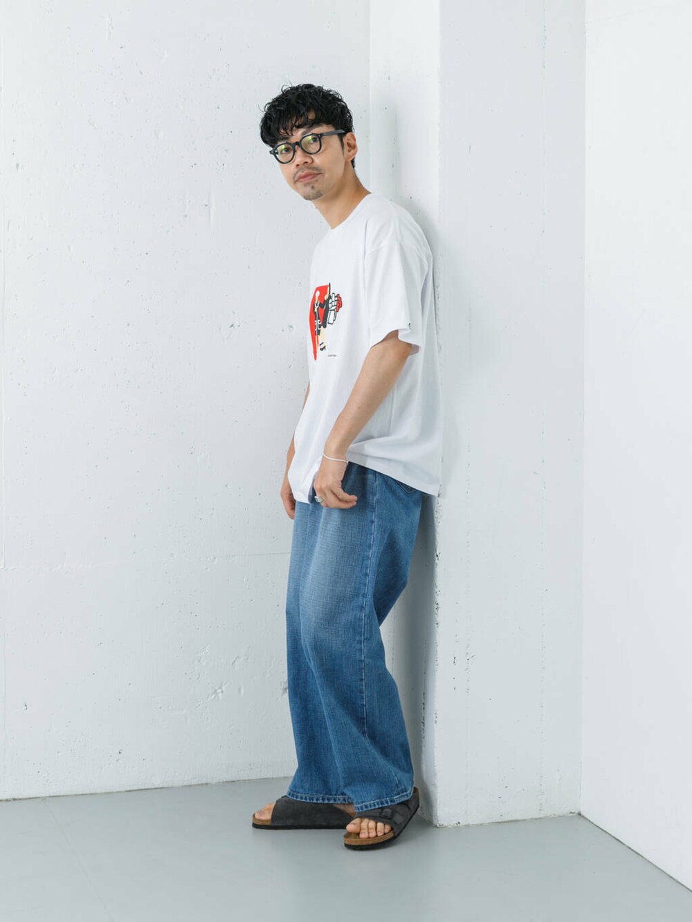ブルー系のデニムパンツ、グレー系のサンダル、ホワイト系のTシャツ/カットソーを着用したメンズの夏コーディネートの5枚目の写真