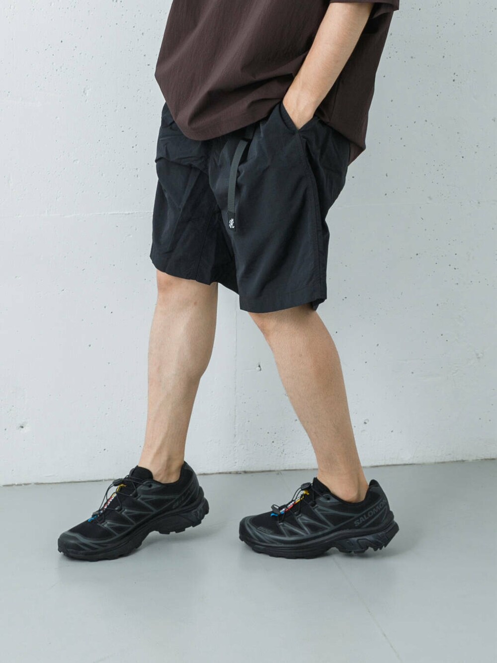 ブラック系のその他パンツ、ブラック系のスニーカー、レッド系のTシャツ/カットソーを着用したメンズの夏コーディネートの3枚目の写真