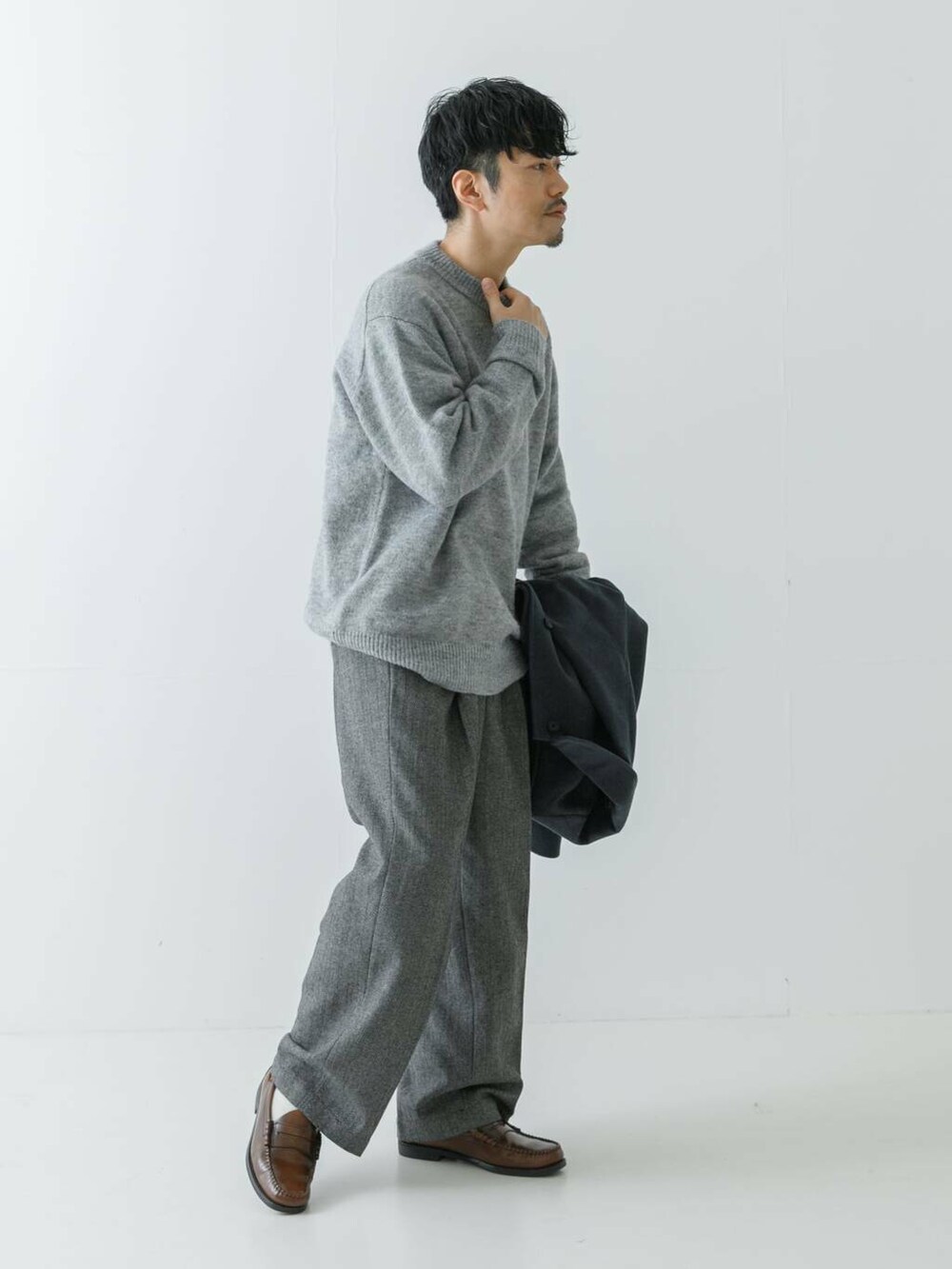 ブルー系のステンカラーコート、グレー系のニット/セーター、グレー系のスラックスを着用したメンズの冬コーディネートの8枚目の写真