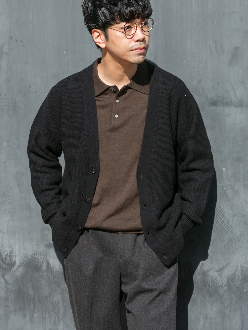 ブラウン系のニット/セーター、ブラック系のカーディガン/ボレロ、グレー系のその他パンツを着用したメンズの秋コーディネートの2枚目の写真
