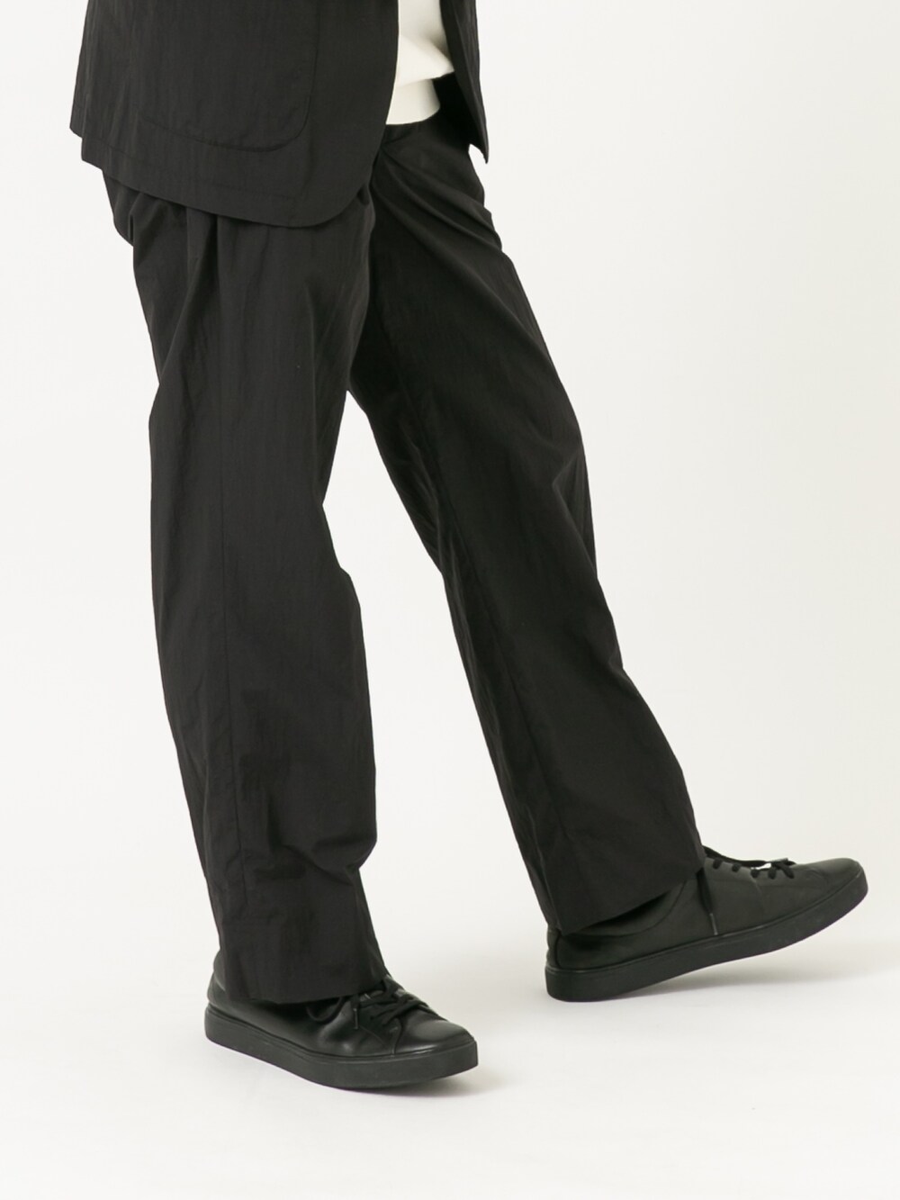 ブラック系のその他アウター、ブラック系のその他パンツ、ホワイト系のニット/セーターを着用したメンズの秋コーディネートの3枚目の写真