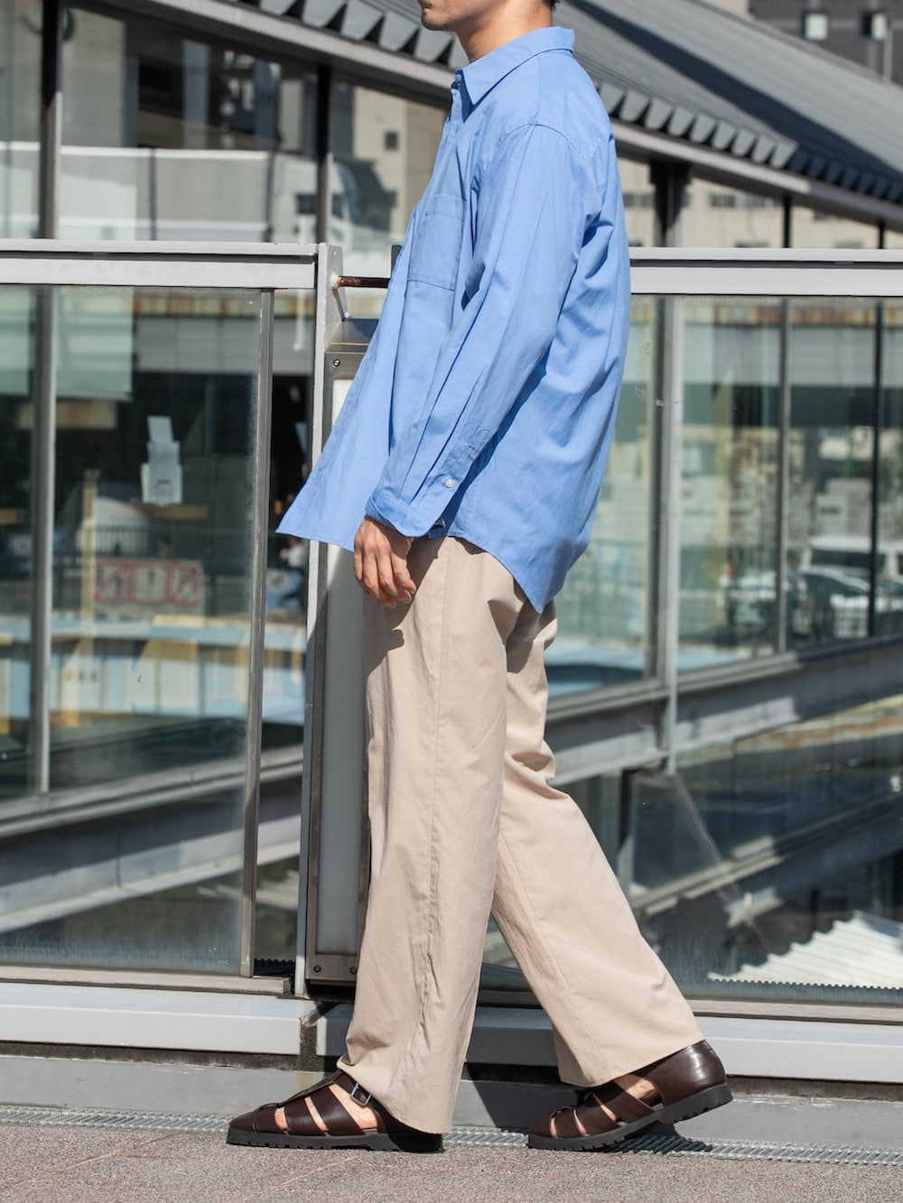 ホワイト系のTシャツ/カットソー、ベージュ系のスラックス、ブルー系のシャツ/ブラウスを着用したメンズの春コーディネートの5枚目の写真