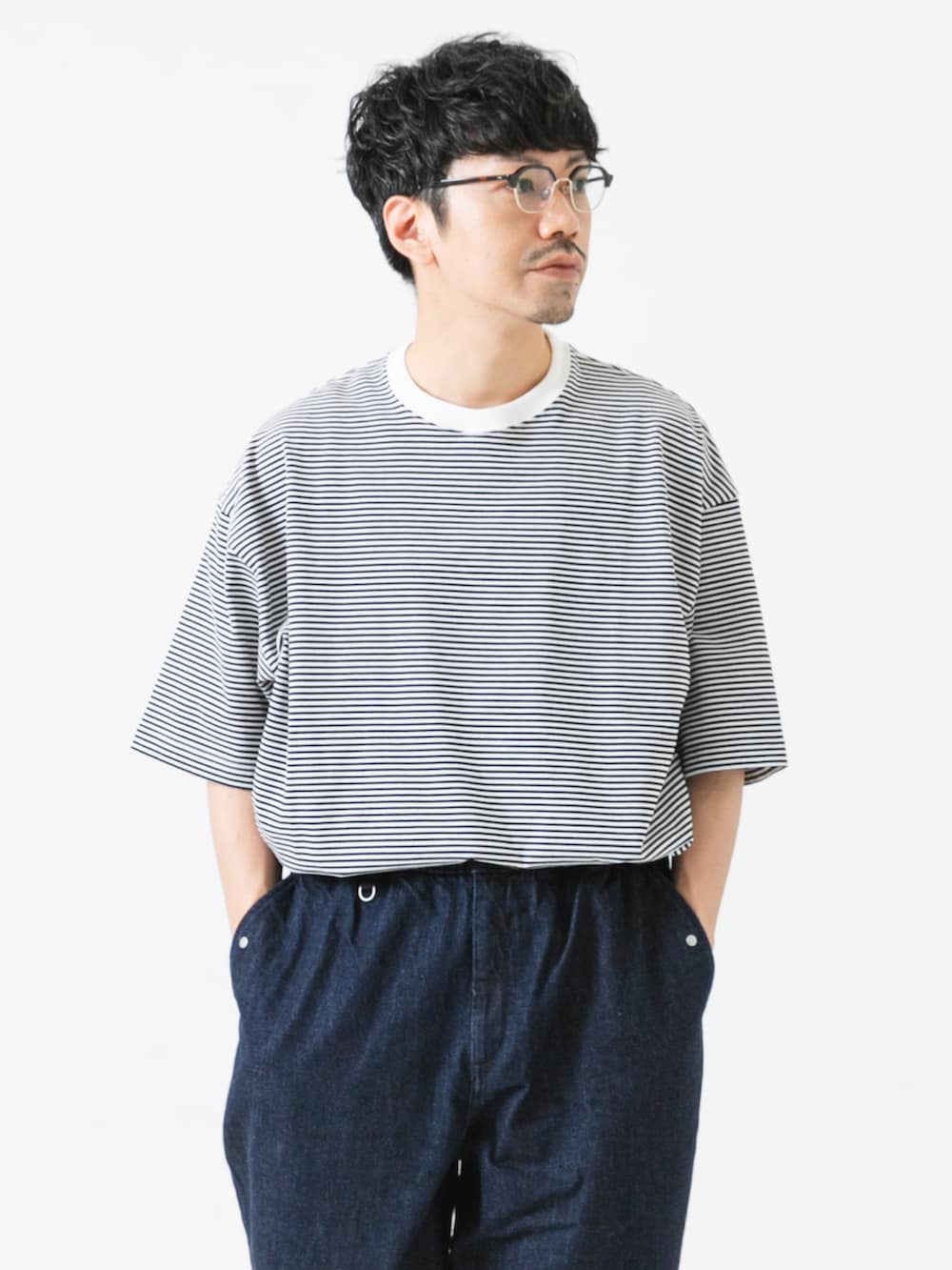 ホワイト系のTシャツ/カットソー、ブルー系のデニムパンツを着用したメンズの夏コーディネートの2枚目の写真