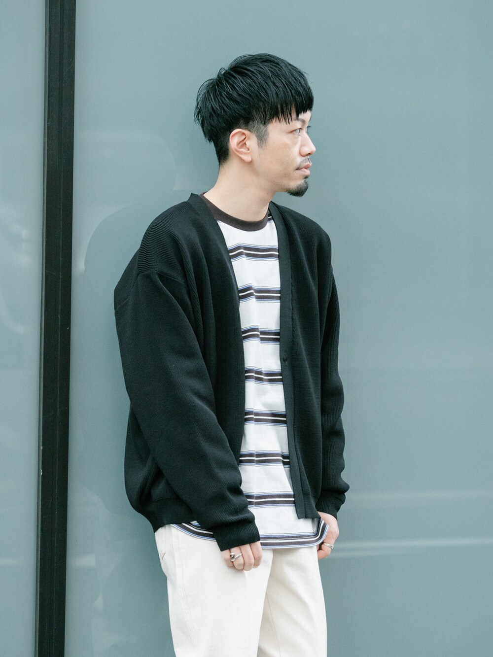 ホワイト系のデニムパンツ、ブラック系のカーディガン/ボレロ、ホワイト系のTシャツ/カットソーを着用したメンズの春コーディネートの3枚目の写真