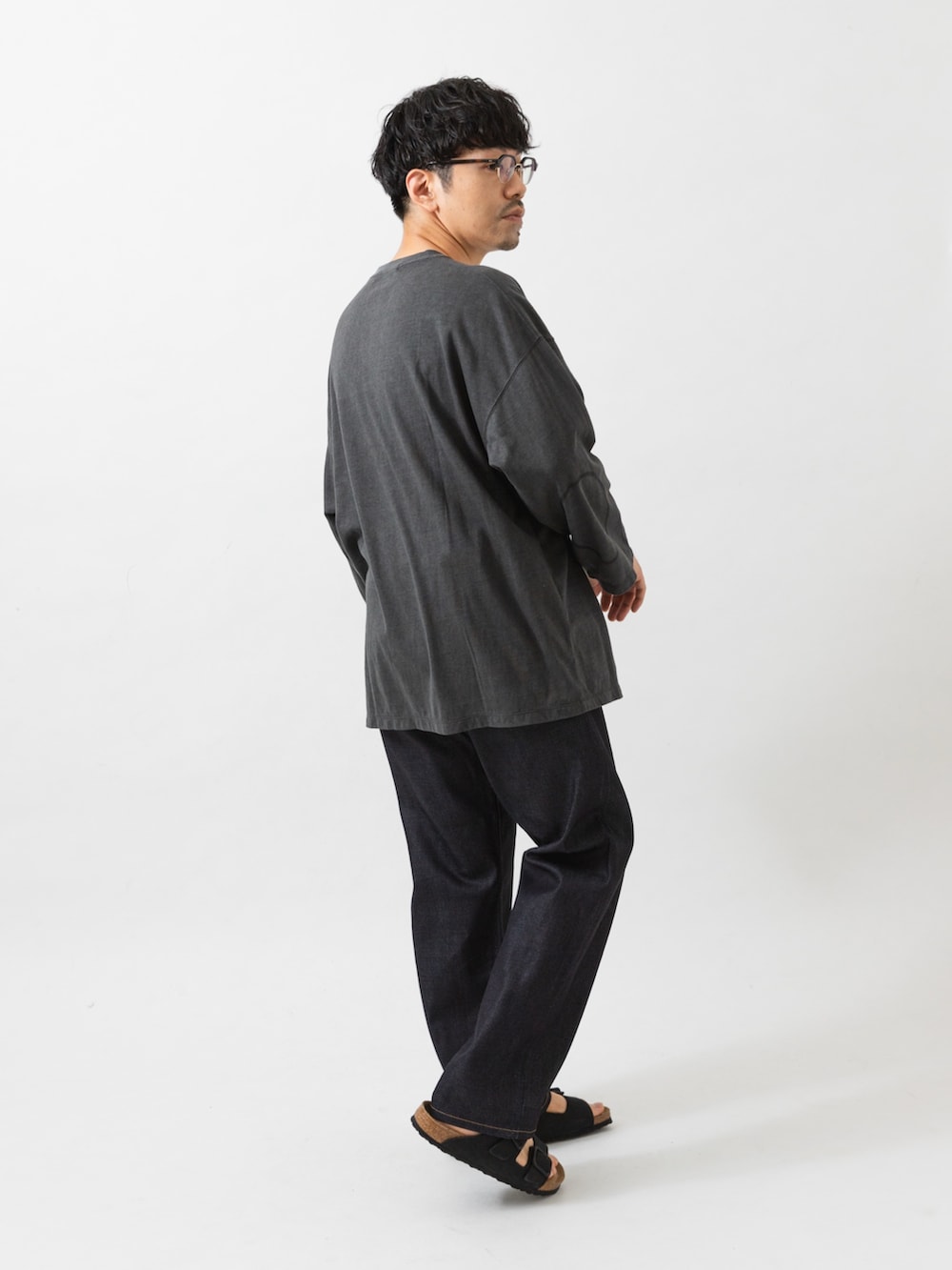 ブラック系のサンダル、ブルー系のデニムパンツ、ブラック系のTシャツ/カットソーを着用したメンズの夏コーディネートの4枚目の写真