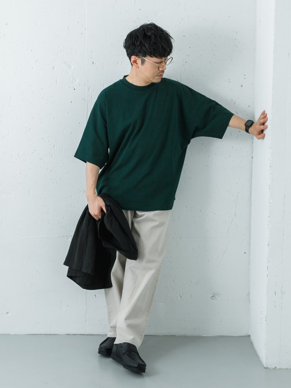 ブラック系のローファー、グリーン系のTシャツ/カットソー、ベージュ系のデニムパンツを着用したメンズの春コーディネートの4枚目の写真
