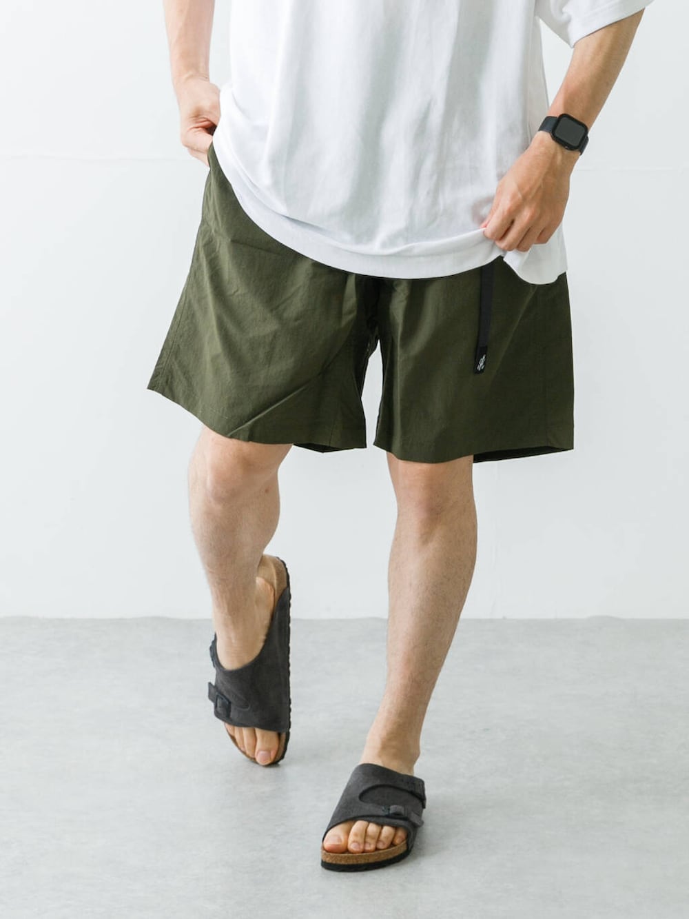 グリーン系のその他パンツ、グレー系のサンダル、ホワイト系のTシャツ/カットソーを着用したメンズの春コーディネートの3枚目の写真
