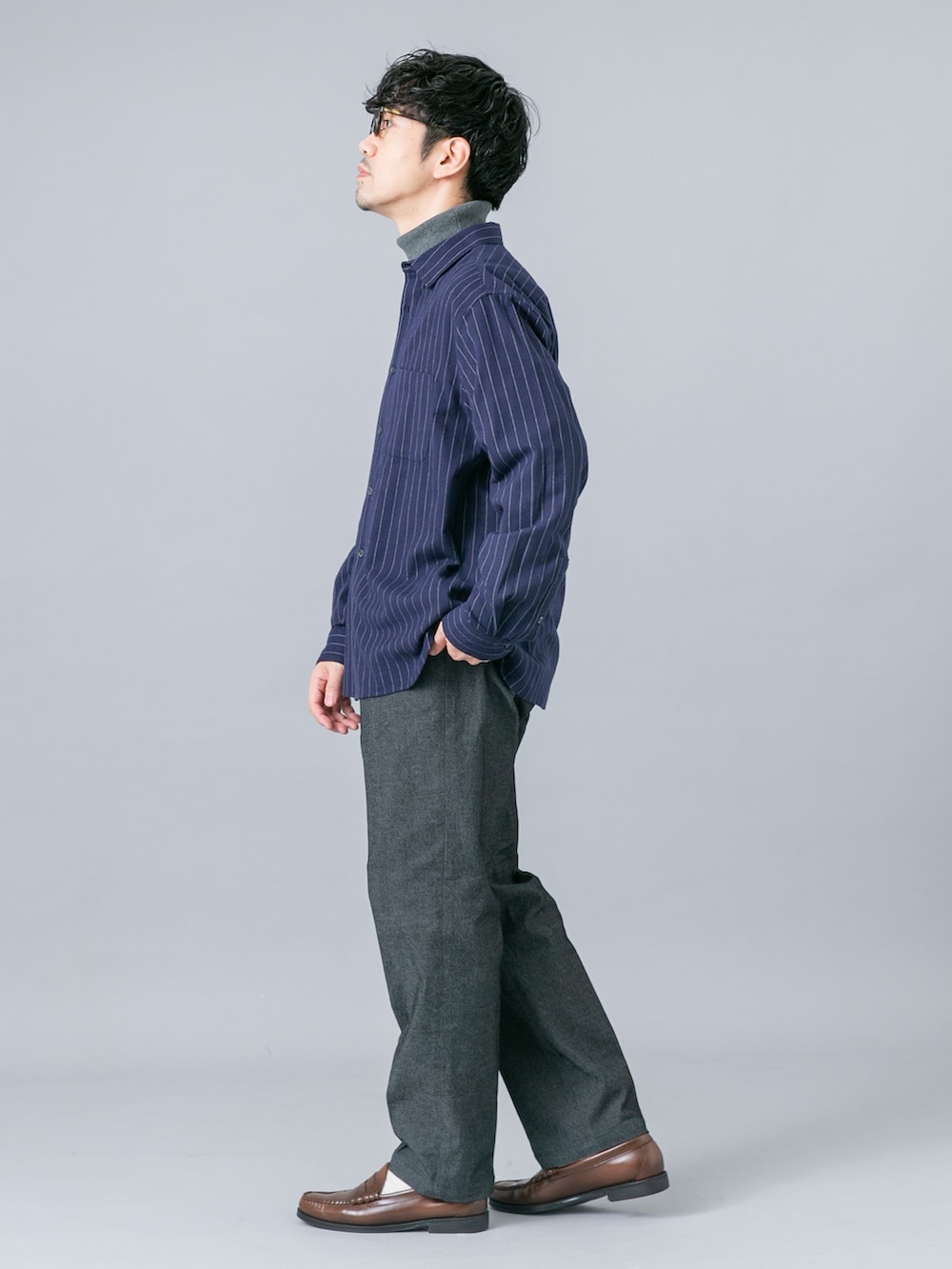 ブルー系のシャツ/ブラウス、グレー系のニット/セーター、ブラック系のデニムパンツを着用したメンズの秋コーディネートの3枚目の写真