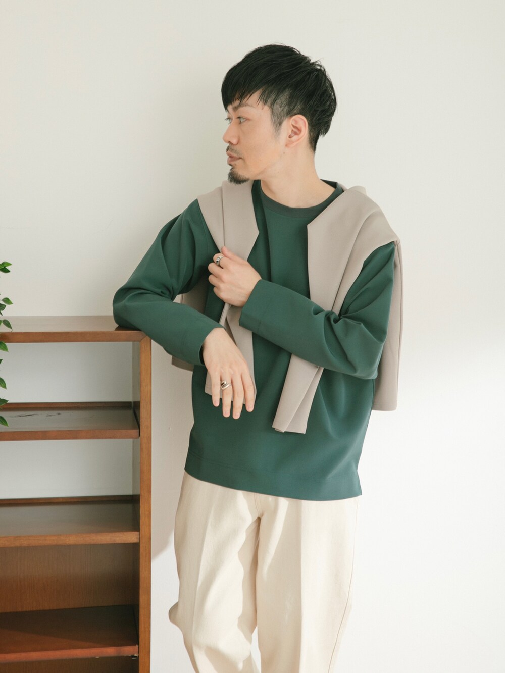 グリーン系のTシャツ/カットソー、ホワイト系のデニムパンツ、ベージュ系のカーディガン/ボレロを着用したメンズの春コーディネートの2枚目の写真