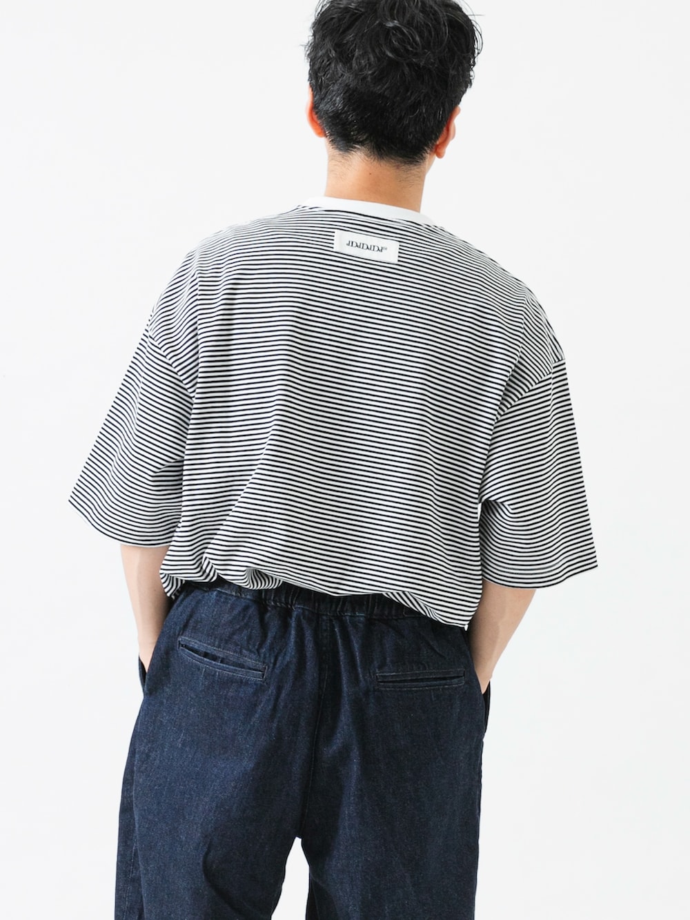 ホワイト系のTシャツ/カットソー、ブルー系のデニムパンツを着用したメンズの夏コーディネートの6枚目の写真