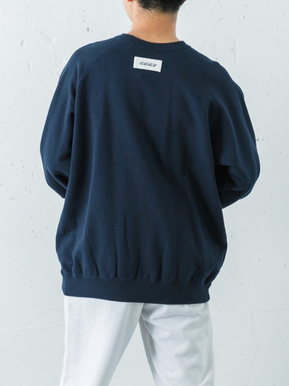 ブルー系のスウェット、グリーン系のスウェットパンツ、ブルー系のスニーカーを着用したメンズの秋コーディネートの6枚目の写真