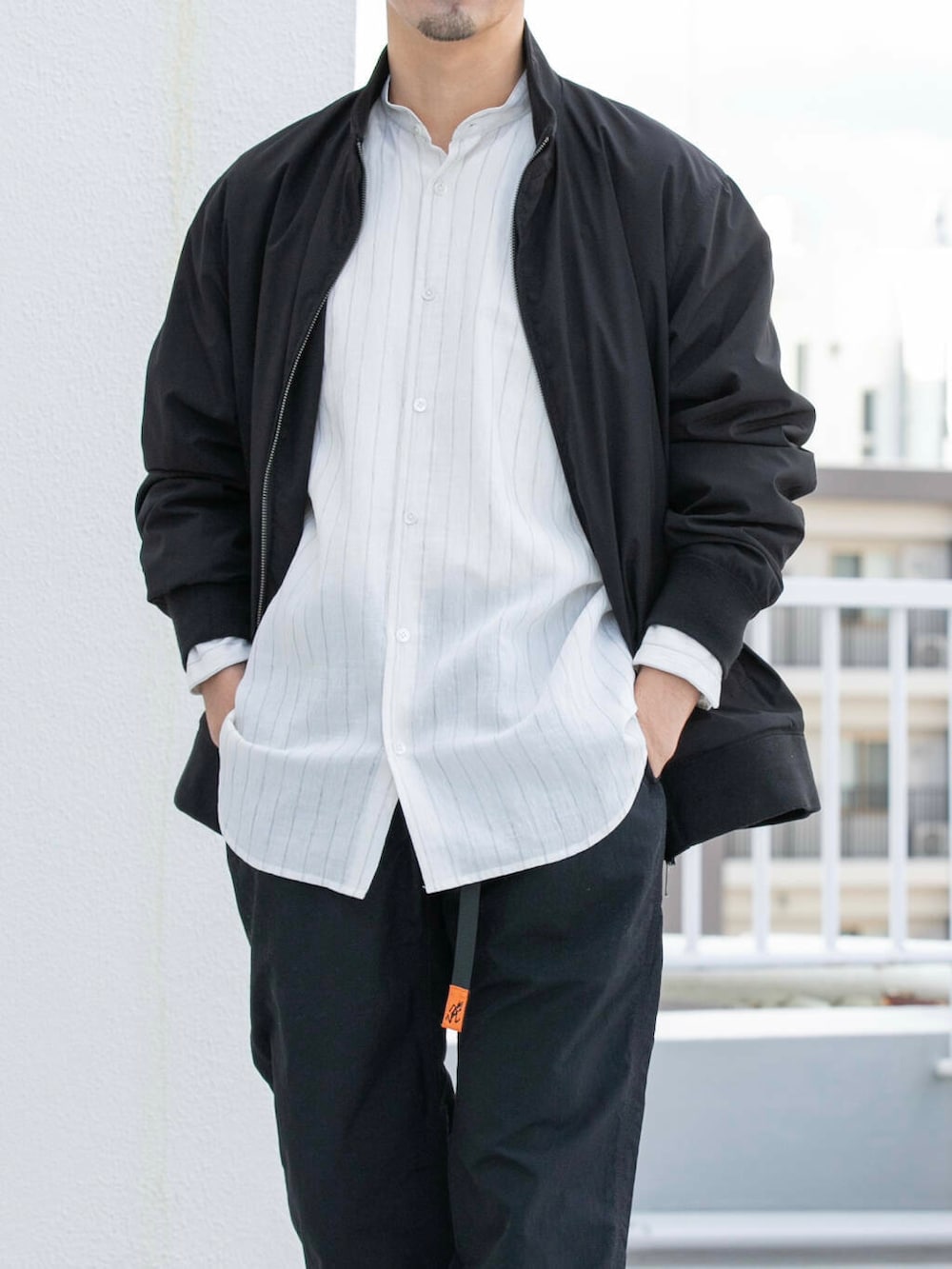 ブラック系のその他パンツ、ブラック系のブルゾン、ホワイト系のシャツ/ブラウスを着用したメンズの冬コーディネートの2枚目の写真