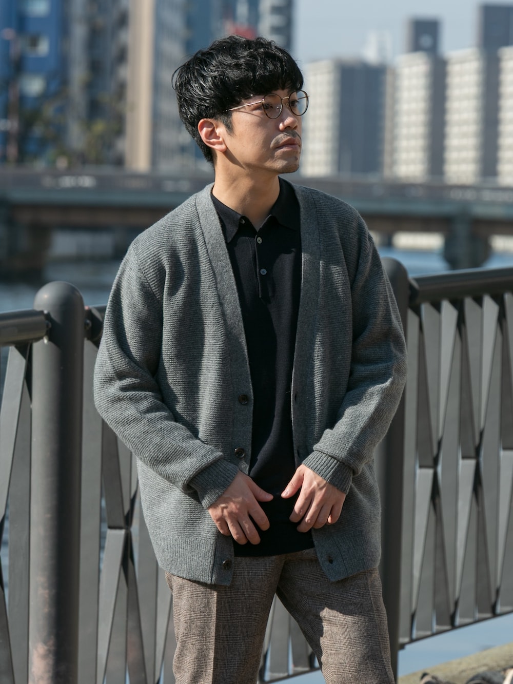 ブラウン系のスラックス、ブルー系のニット/セーター、グレー系のカーディガン/ボレロを着用したメンズの冬コーディネートの2枚目の写真