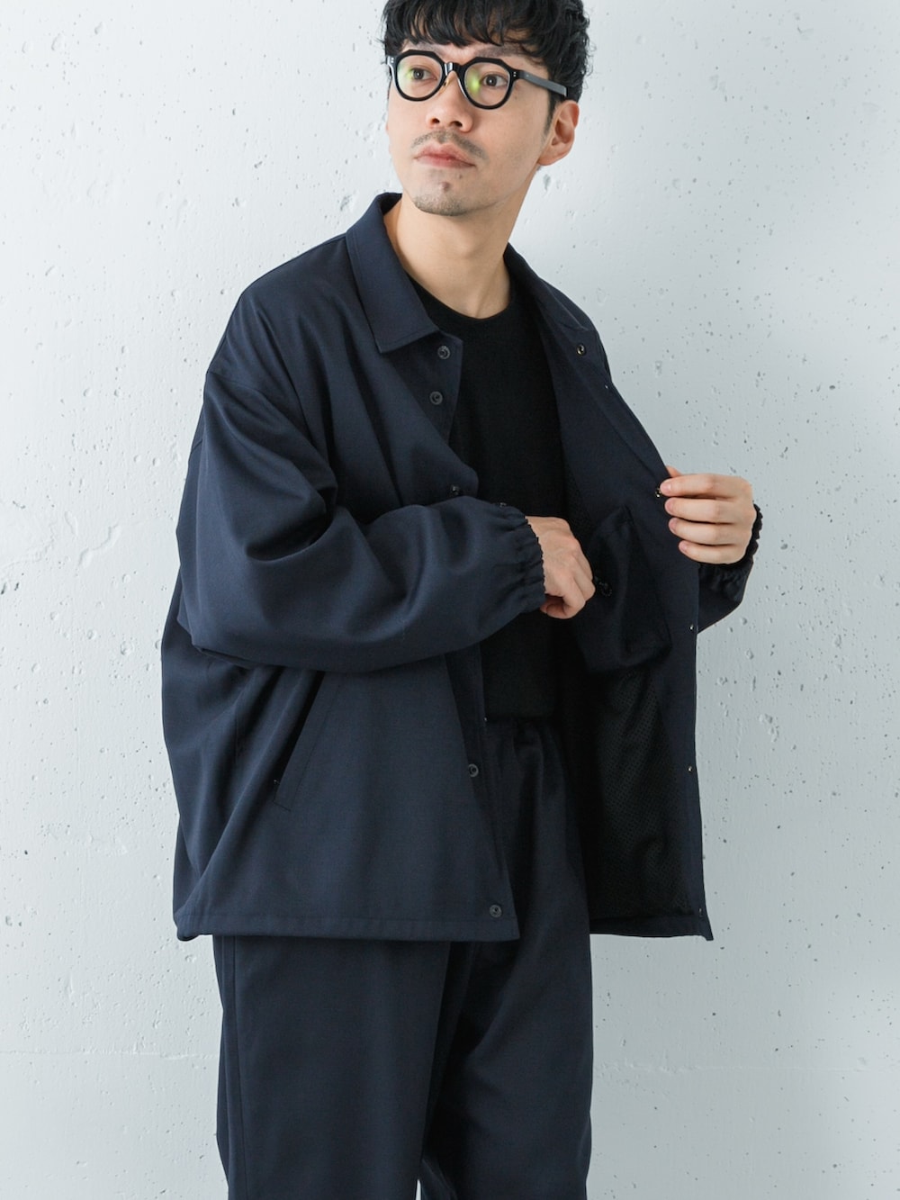 ブラック系のスニーカー、ブルー系のその他アウター、ブルー系のその他パンツを着用したメンズの冬コーディネートの2枚目の写真