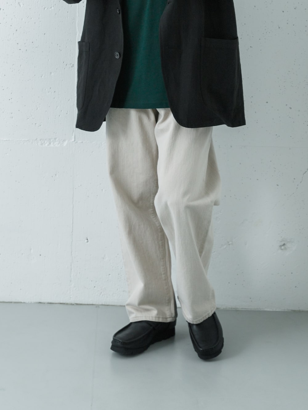 ブラック系のローファー、グリーン系のTシャツ/カットソー、ベージュ系のデニムパンツを着用したメンズの春コーディネートの3枚目の写真