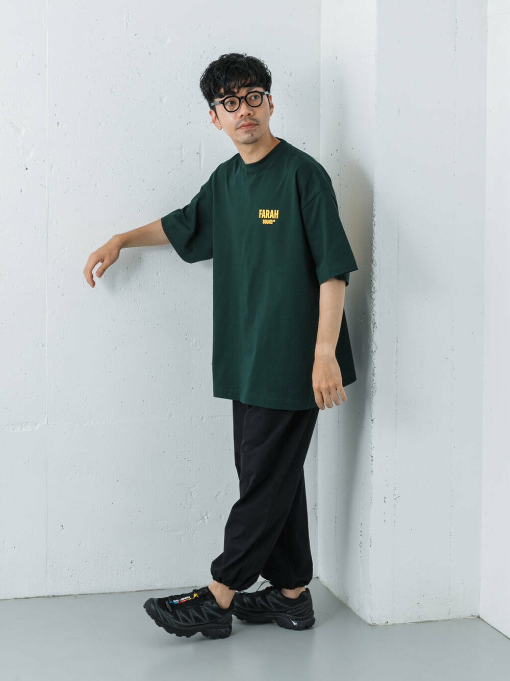 ブラック系のスニーカー、ブルー系のその他パンツ、グリーン系のTシャツ/カットソーを着用したメンズの夏コーディネートの2枚目の写真