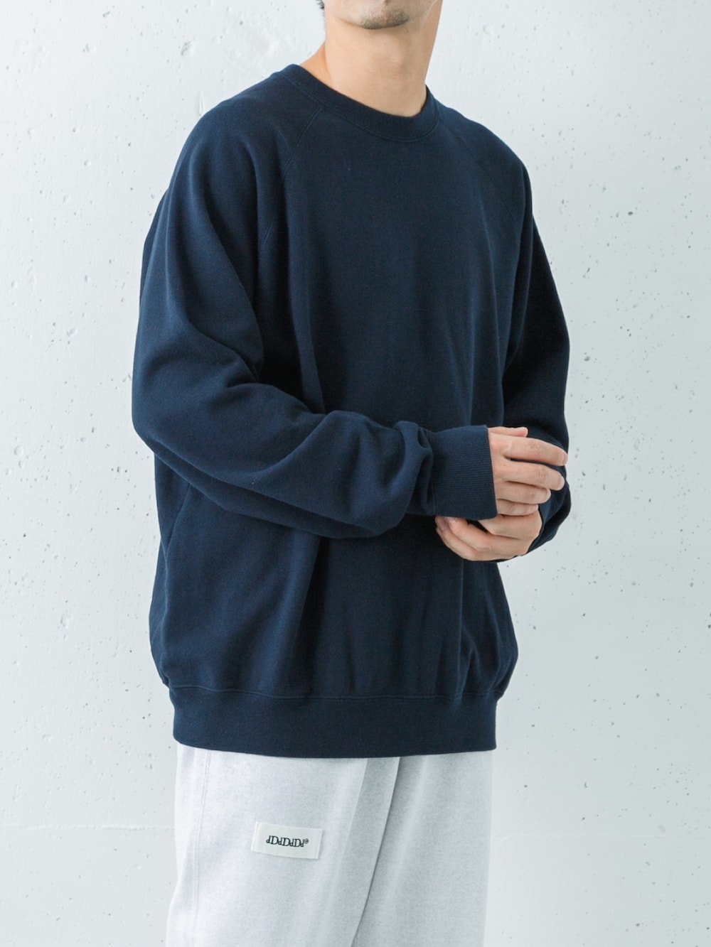 ブルー系のスウェット、グリーン系のスウェットパンツ、ブルー系のスニーカーを着用したメンズの秋コーディネートの2枚目の写真