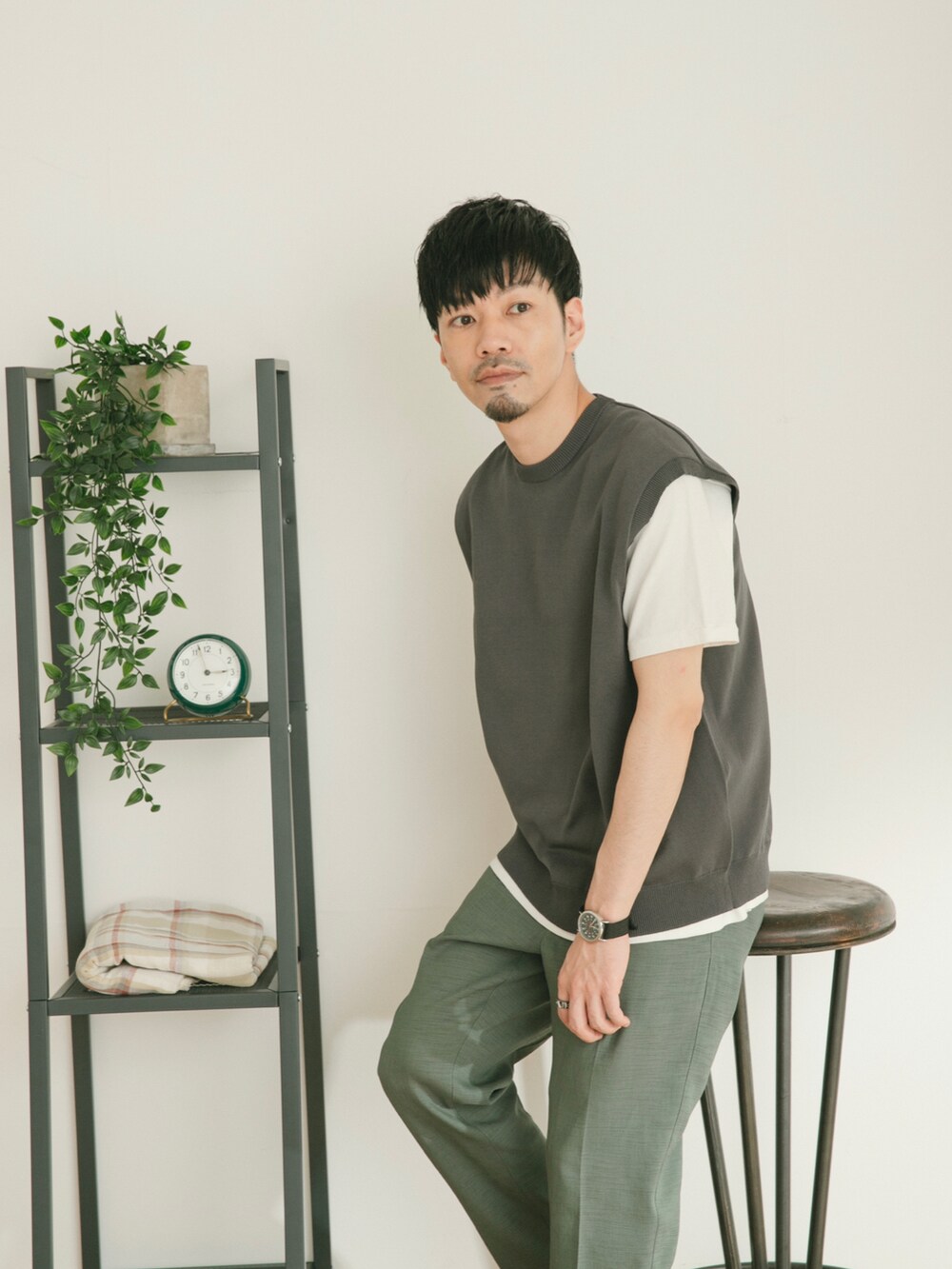 グレー系のベスト、グリーン系のスラックス、ホワイト系のその他を着用したメンズの春コーディネートの3枚目の写真