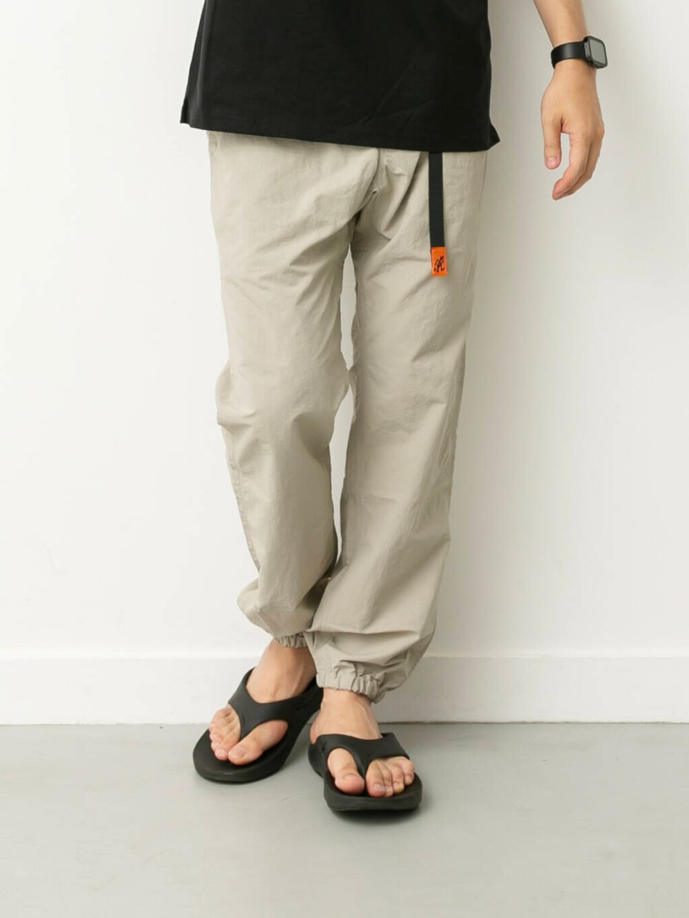 ベージュ系のその他パンツ、ブラック系のサンダル、ブラック系のポロシャツを着用したメンズの夏コーディネートの3枚目の写真