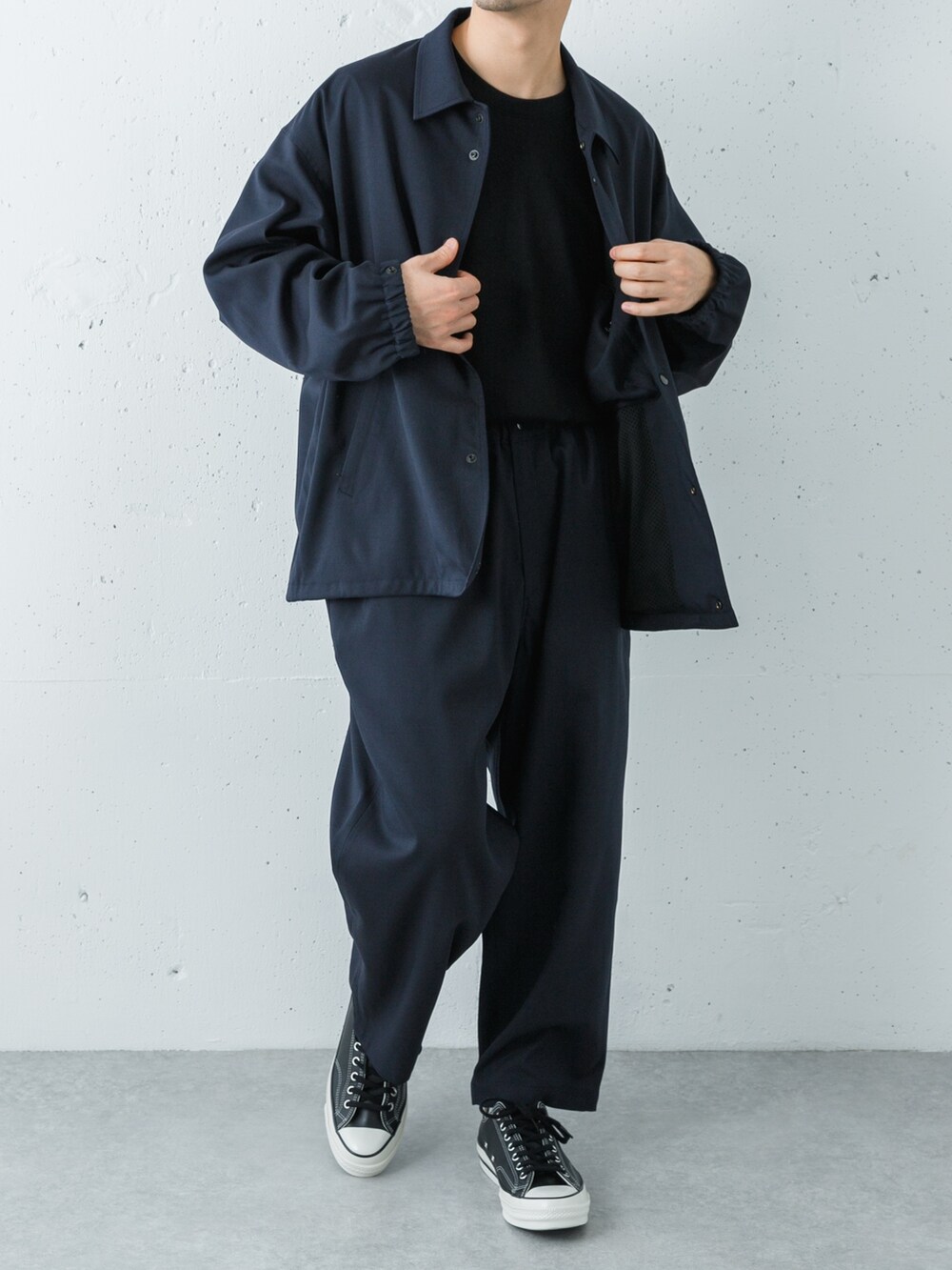 ブラック系のスニーカー、ブルー系のその他アウター、ブルー系のその他パンツを着用したメンズの冬コーディネートの3枚目の写真