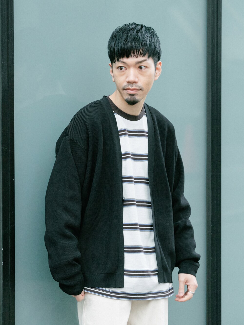 ホワイト系のデニムパンツ、ブラック系のカーディガン/ボレロ、ホワイト系のTシャツ/カットソーを着用したメンズの春コーディネートの2枚目の写真