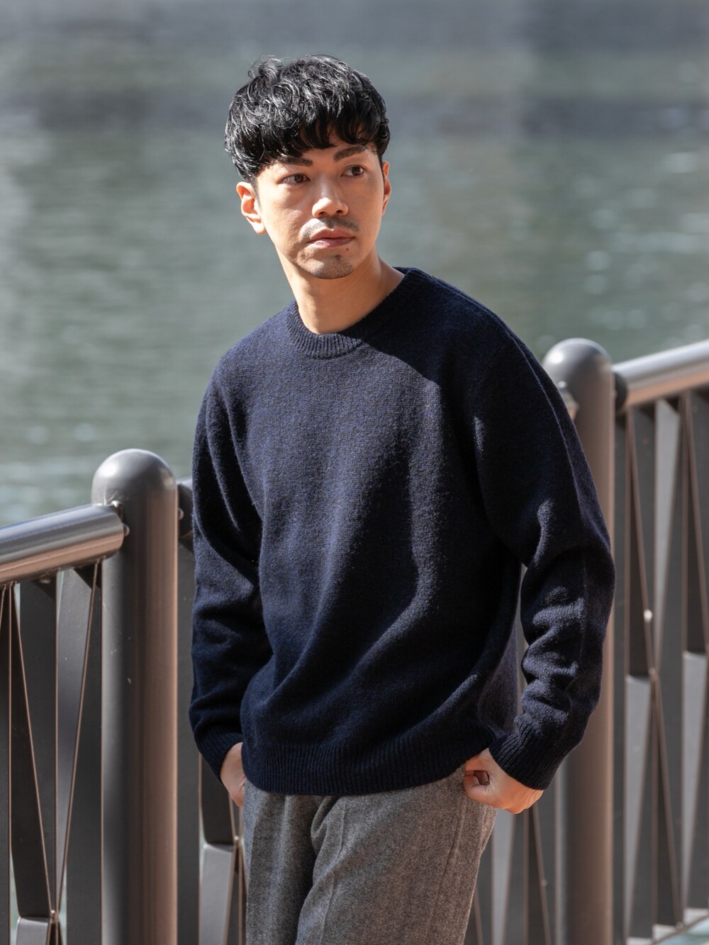 ブルー系のニット/セーター、グレー系のその他パンツを着用したメンズの秋コーディネートの2枚目の写真