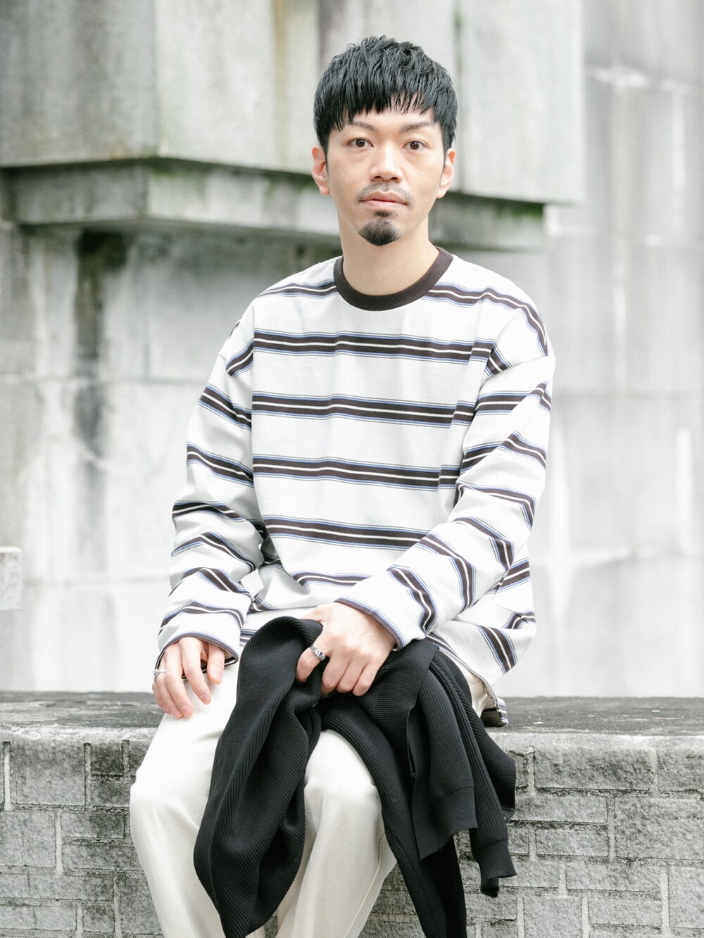 ホワイト系のデニムパンツ、ブラック系のカーディガン/ボレロ、ホワイト系のTシャツ/カットソーを着用したメンズの春コーディネートの4枚目の写真