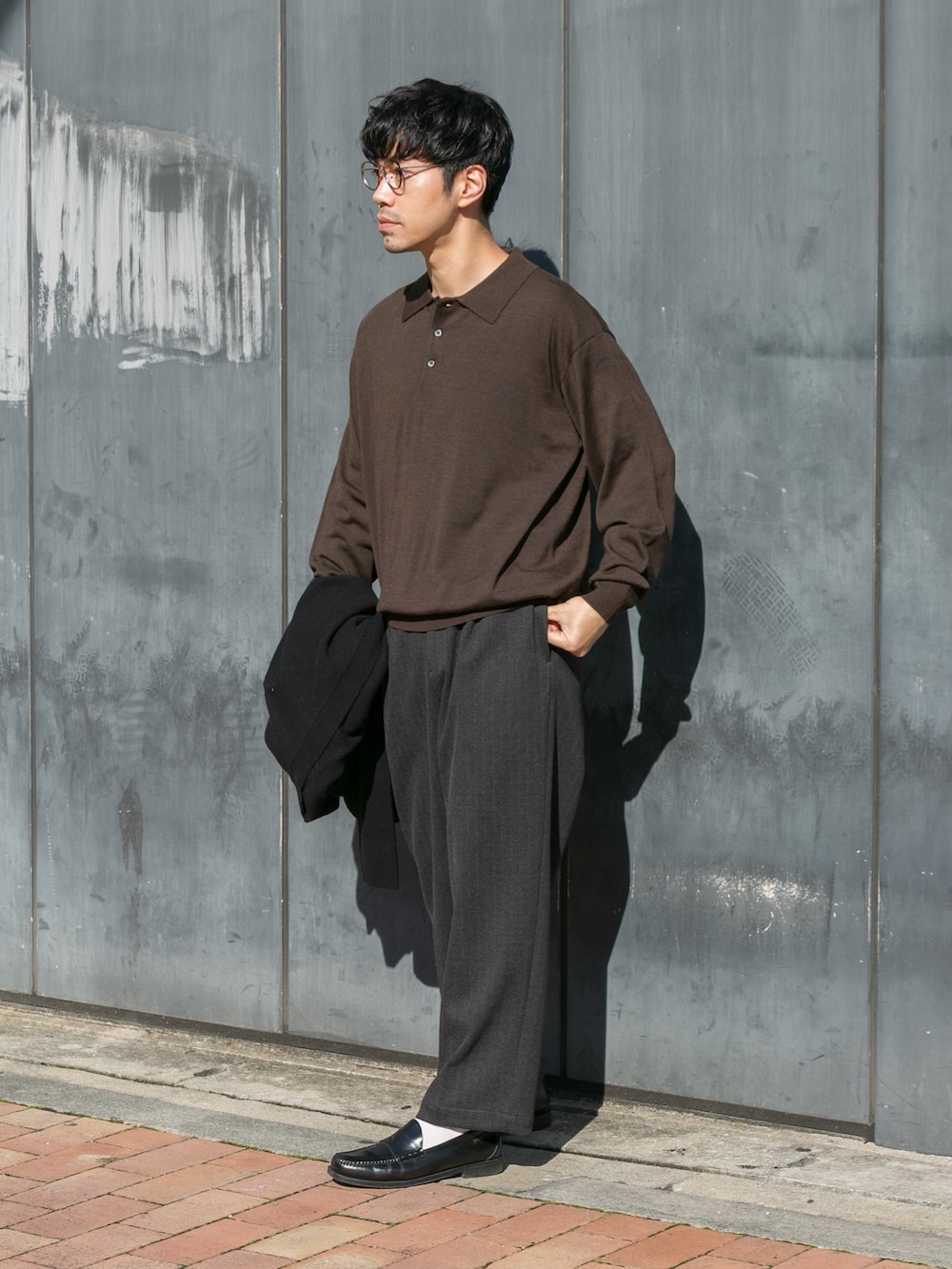 ブラウン系のニット/セーター、ブラック系のカーディガン/ボレロ、グレー系のその他パンツを着用したメンズの秋コーディネートの4枚目の写真