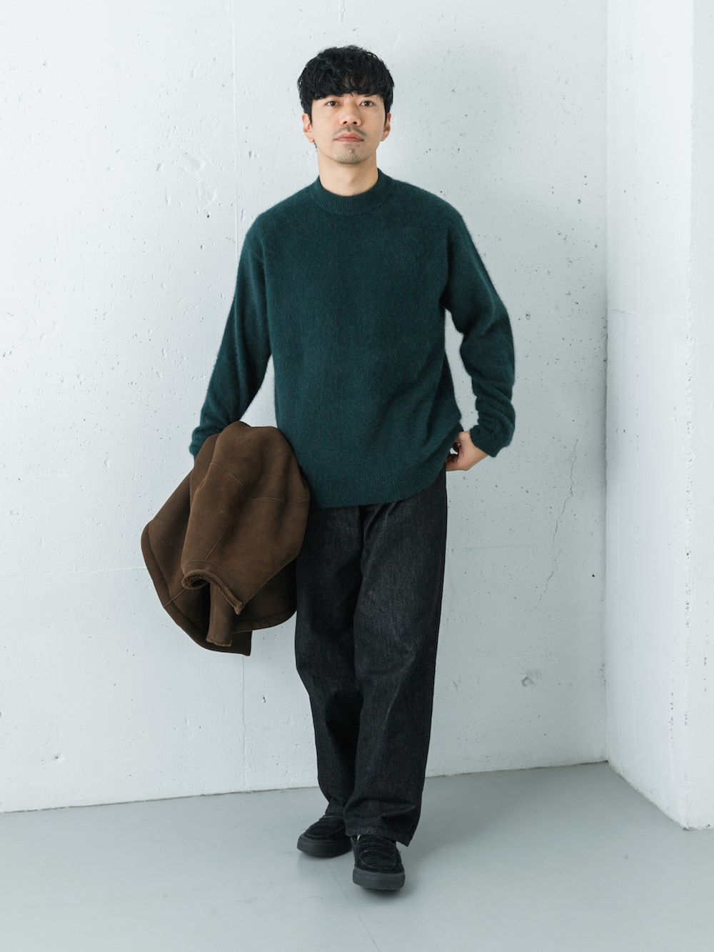 ブラック系のデニムパンツ、ブラウン系のテーラードジャケット、グリーン系のニット/セーターを着用したメンズの秋コーディネートの4枚目の写真