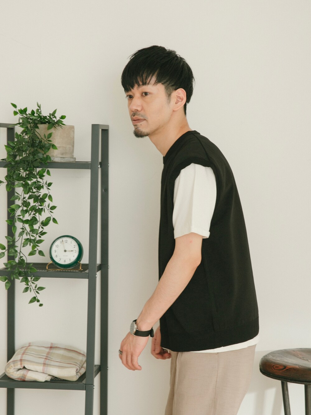 ベージュ系のスラックス、ブラック系のベスト、ホワイト系のその他を着用したメンズの春コーディネートの3枚目の写真