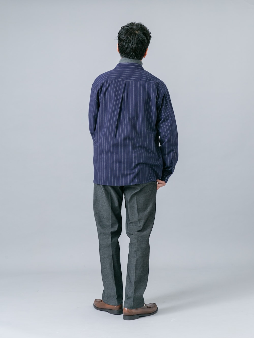 ブルー系のシャツ/ブラウス、グレー系のニット/セーター、ブラック系のデニムパンツを着用したメンズの秋コーディネートの4枚目の写真