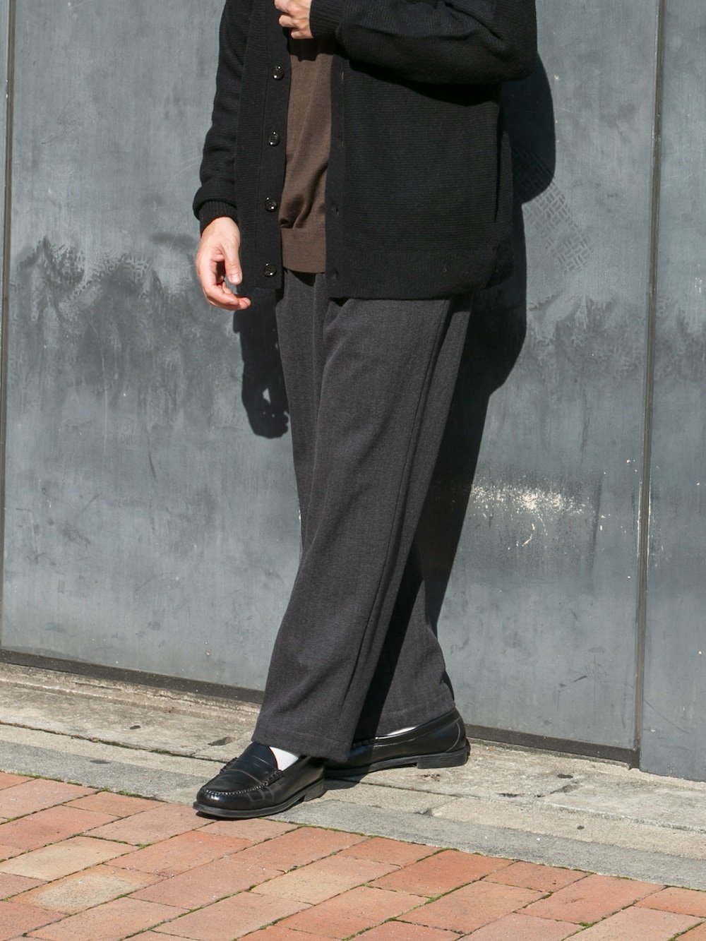 ブラウン系のニット/セーター、ブラック系のカーディガン/ボレロ、グレー系のその他パンツを着用したメンズの秋コーディネートの3枚目の写真