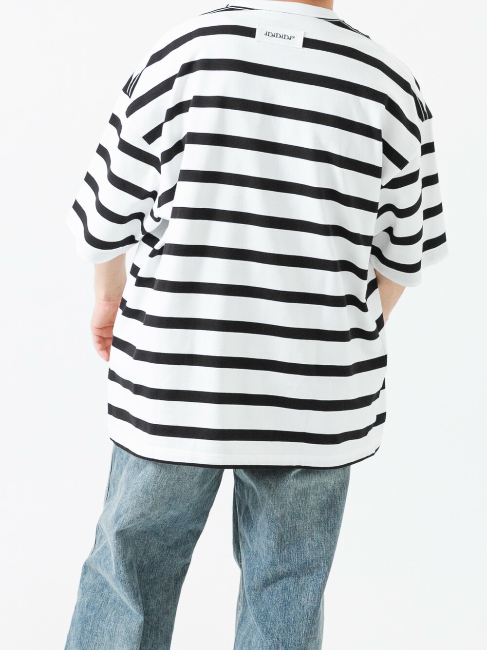 ブラック系のスニーカー、ホワイト系のTシャツ/カットソー、ブルー系のデニムパンツを着用したメンズの夏コーディネートの6枚目の写真