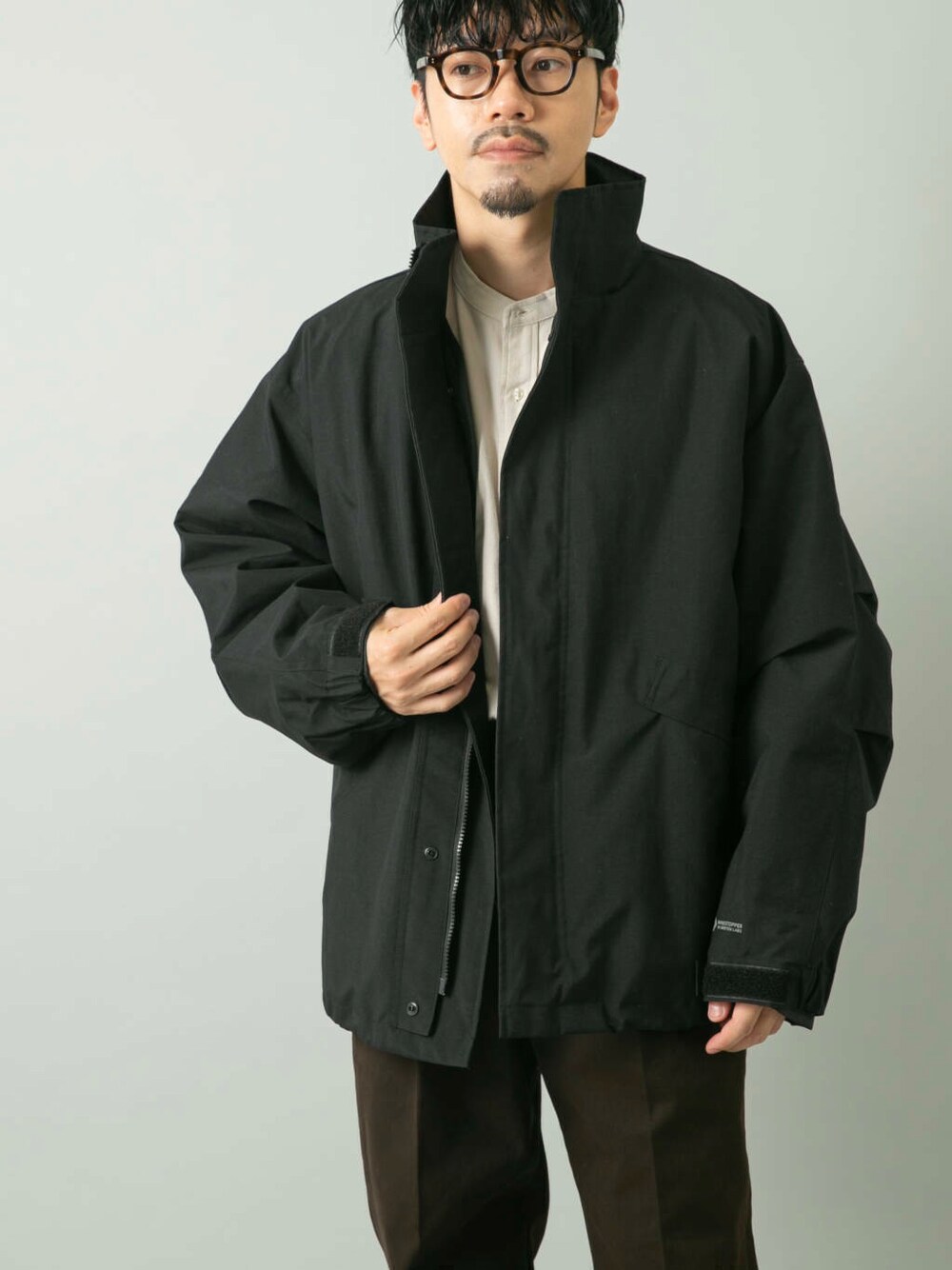 ブラウン系のその他パンツ、ブラック系のモッズコートを着用したメンズの秋コーディネートの2枚目の写真