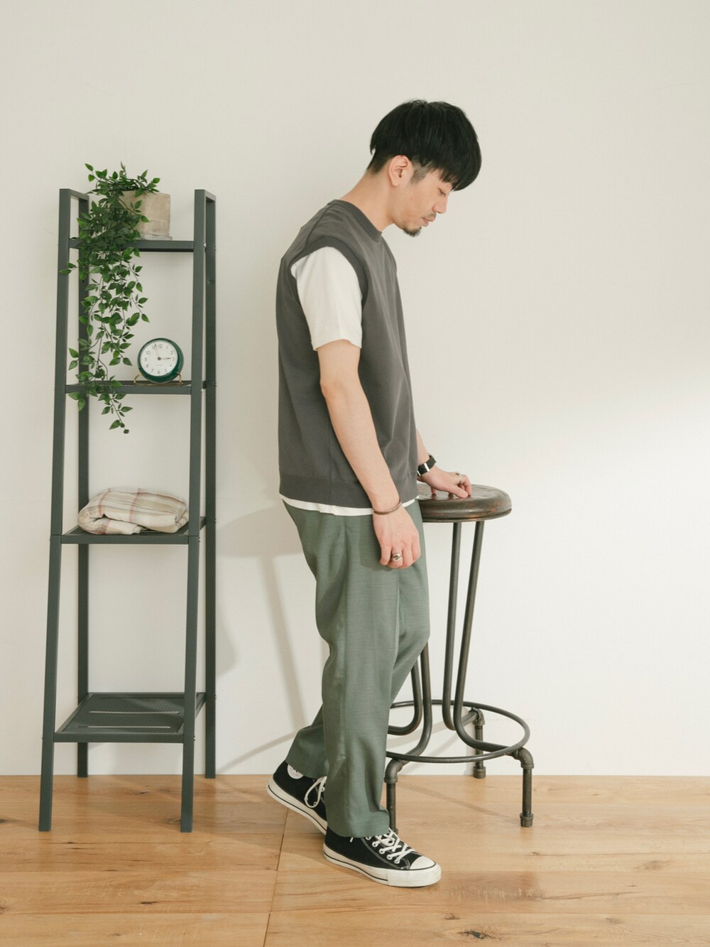 グレー系のベスト、グリーン系のスラックス、ホワイト系のその他を着用したメンズの春コーディネートの2枚目の写真