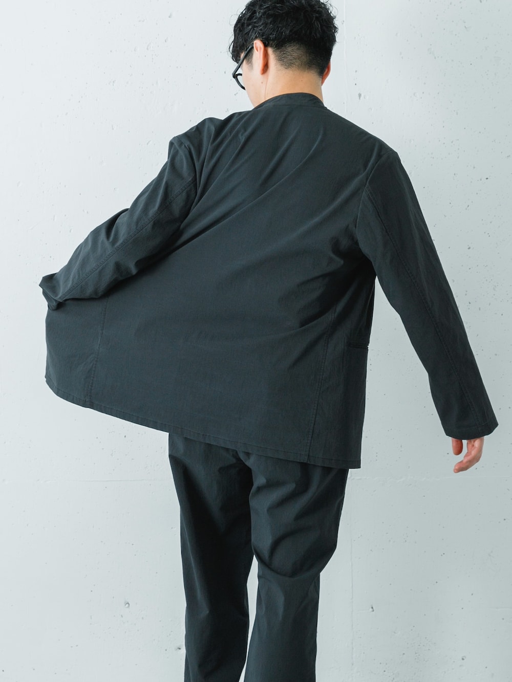 ブラック系のその他アウター、ブラック系のスニーカー、ブラック系のその他パンツを着用したメンズの冬コーディネートの6枚目の写真