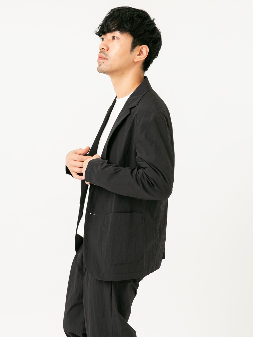 ブラック系のその他アウター、ブラック系のその他パンツ、ホワイト系のニット/セーターを着用したメンズの秋コーディネートの4枚目の写真