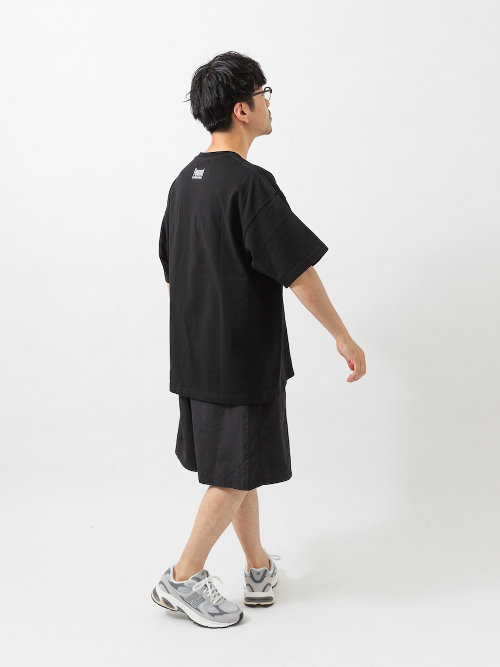 ブラック系のTシャツ/カットソー、ブラック系のその他パンツ、グレー系のスニーカーを着用したメンズの夏コーディネートの4枚目の写真