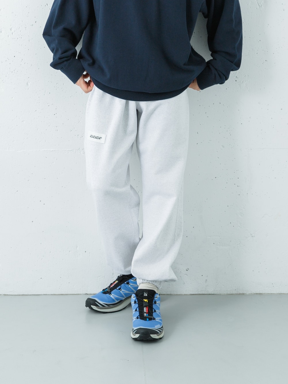 ブルー系のスウェット、グリーン系のスウェットパンツ、ブルー系のスニーカーを着用したメンズの秋コーディネートの3枚目の写真