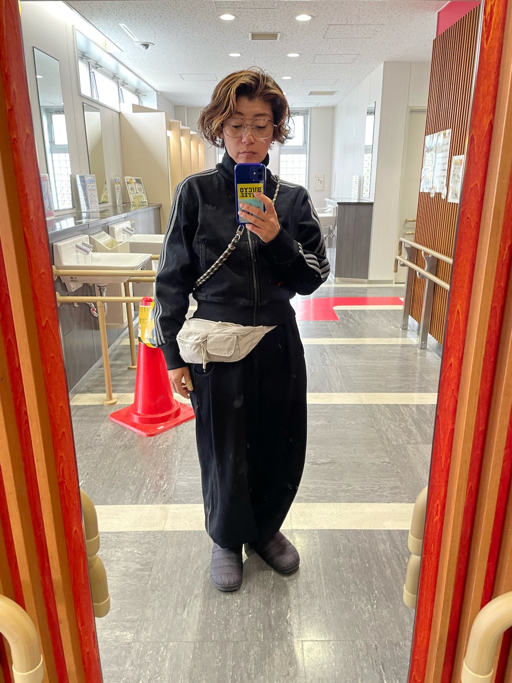 ブラック系のスウェットパンツ、グレー系のボディバッグ/ウエストポーチ、ブラック系のデニムジャケットを着用したレディースの春コーディネートの2枚目の写真