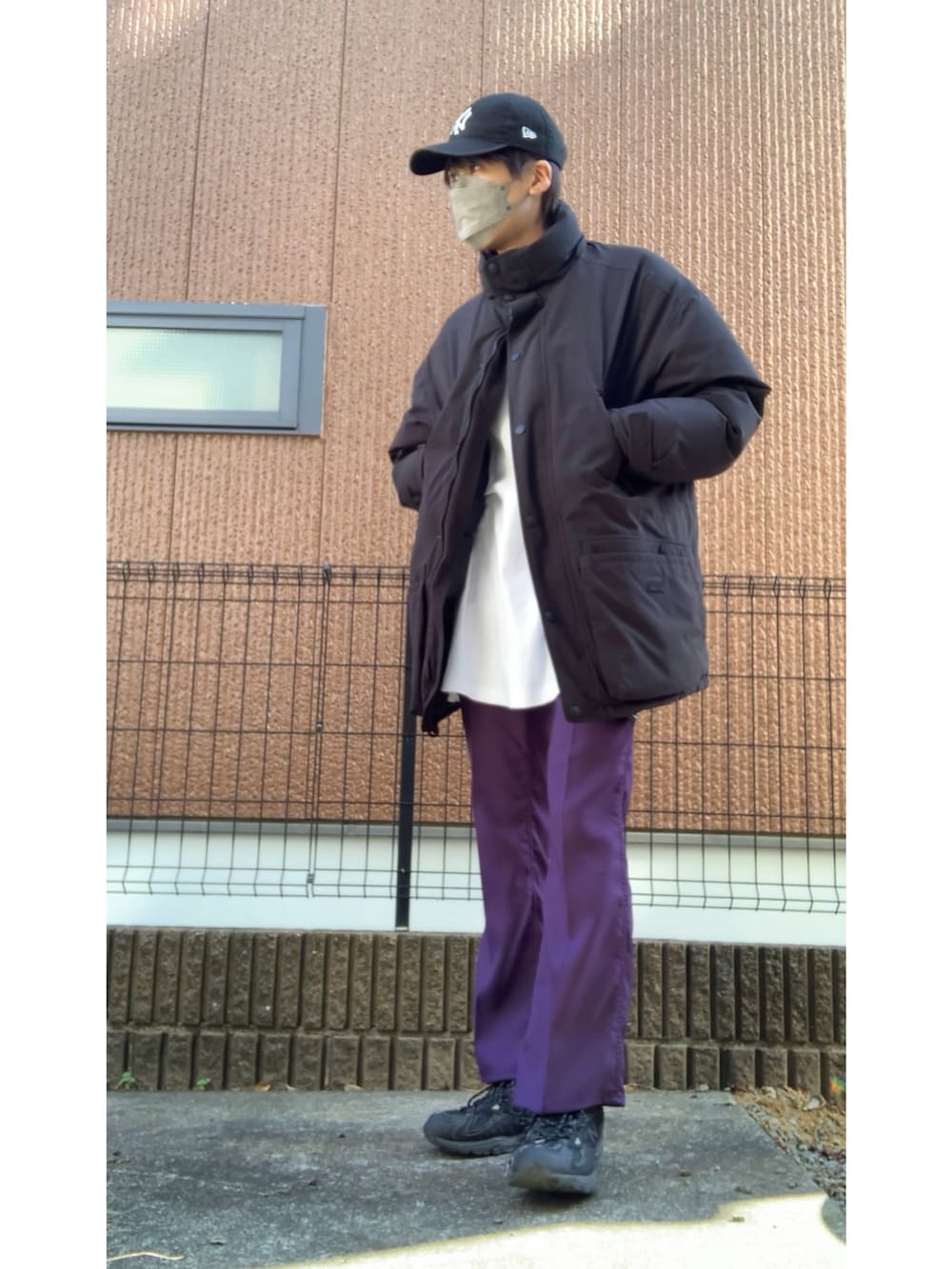 ブラック系のジャケット/アウター、パープル系のパンツ、ブラック系のスニーカーを着用したメンズの冬コーディネートの2枚目の写真
