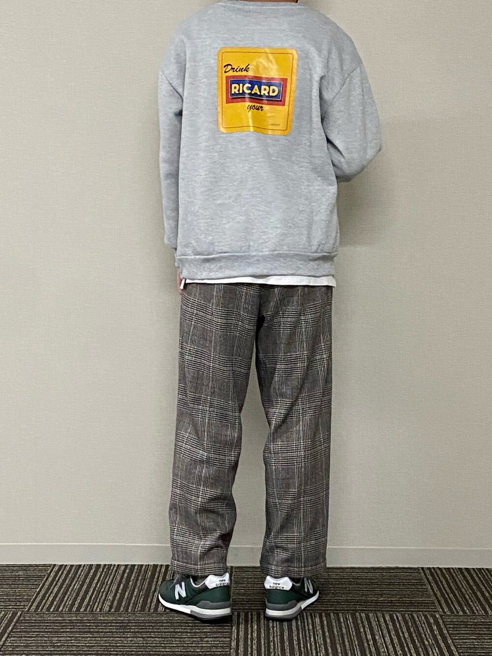 グレー系のスウェット、グリーン系のミリタリージャケット、ブラウン系のスラックスを着用したメンズの春コーディネートの3枚目の写真