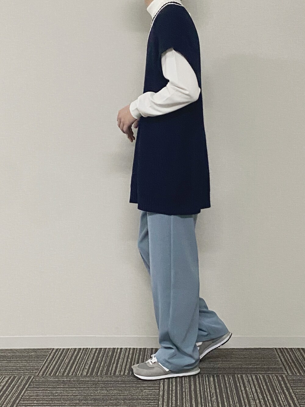 ブルー系のベスト、ホワイト系のニット/セーター、グレー系のスラックスを着用したメンズの春コーディネートの2枚目の写真