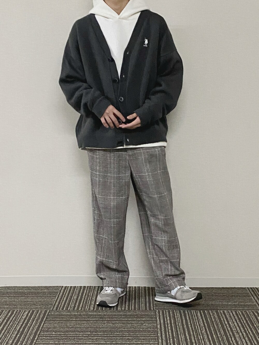 ホワイト系のパーカー、グレー系のカーディガン/ボレロ、ブラウン系のスラックスを着用したメンズの春コーディネートの2枚目の写真