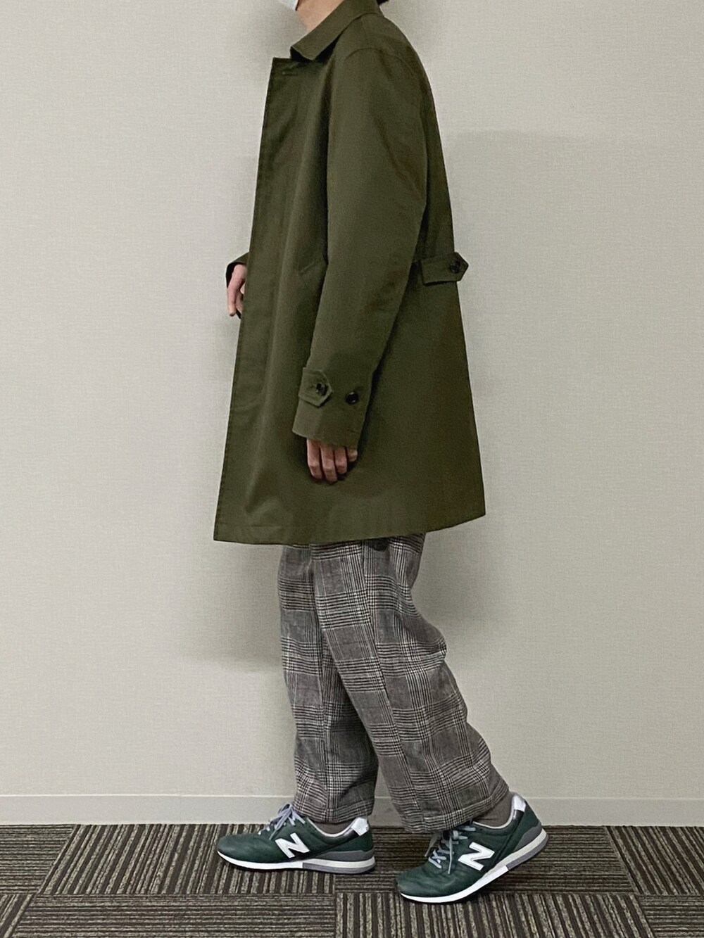 グレー系のスウェット、グリーン系のミリタリージャケット、ブラウン系のスラックスを着用したメンズの春コーディネートの2枚目の写真