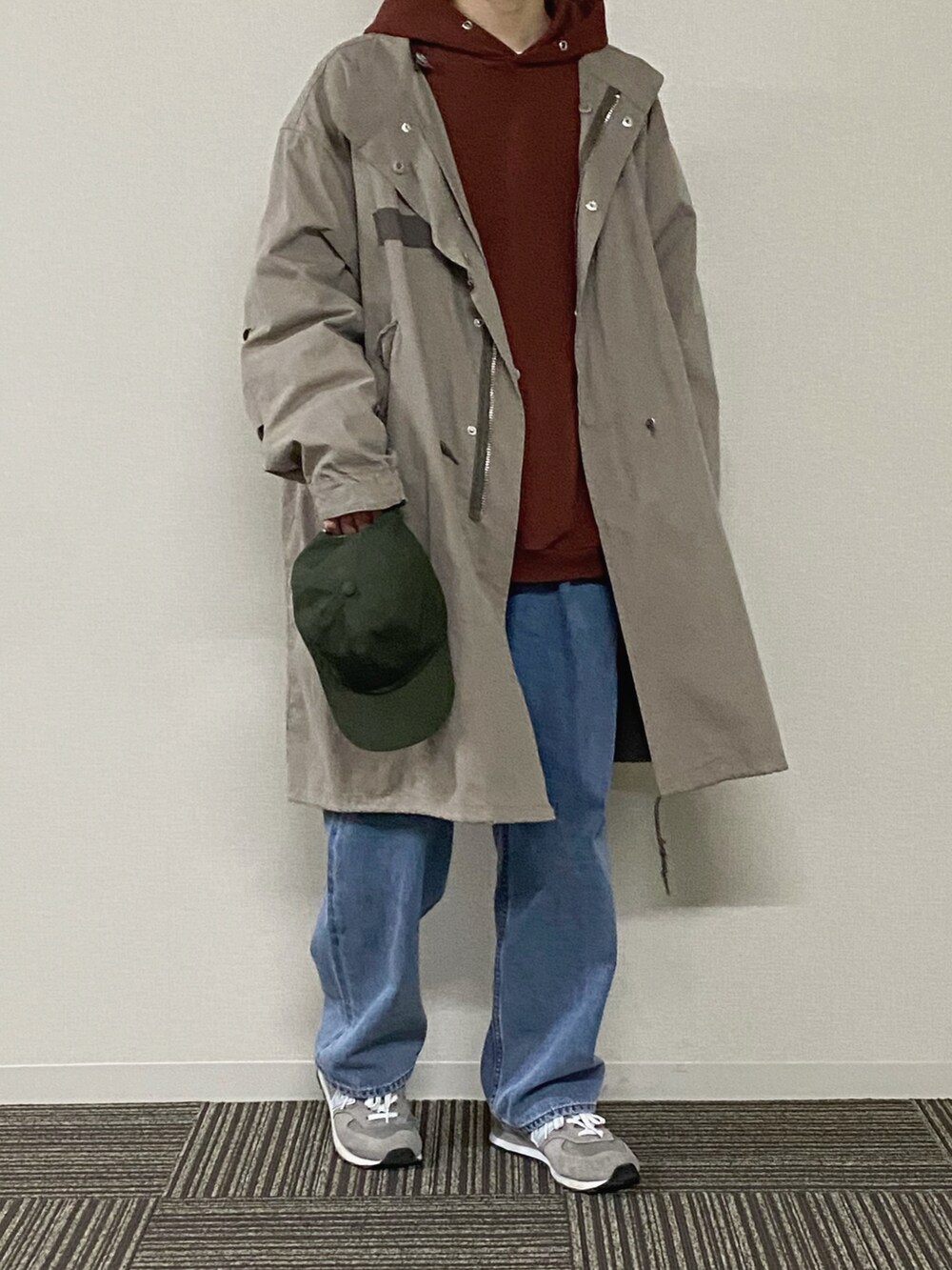 ブラウン系のパーカー、ベージュ系のその他アウター、ブルー系のデニムパンツを着用したメンズの冬コーディネートの2枚目の写真