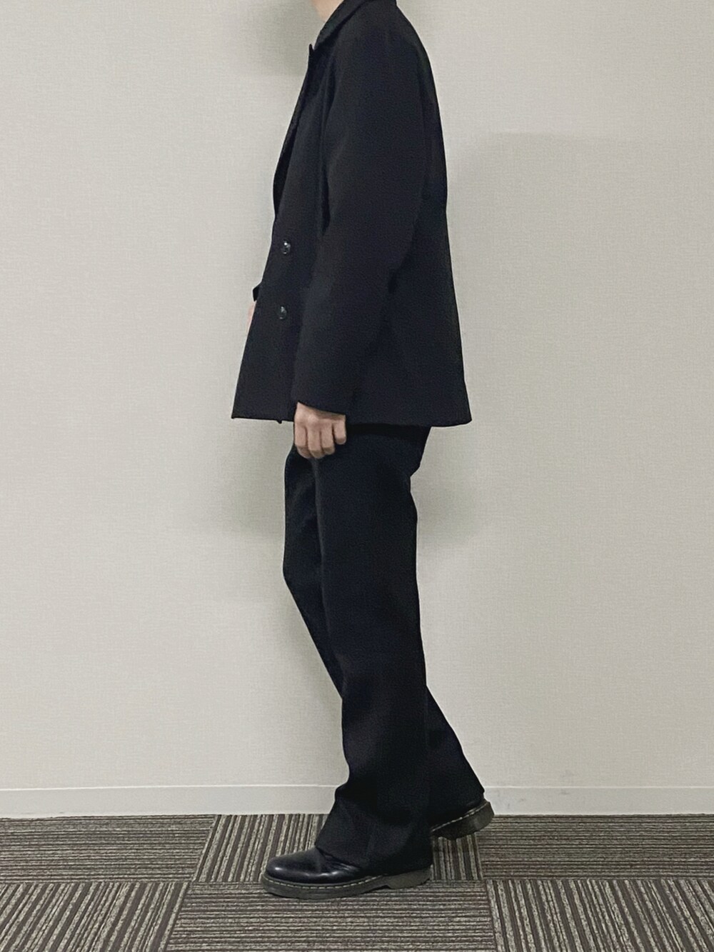 グリーン系のスウェット、ブラック系のテーラードジャケット、ブラック系のスラックスを着用したメンズの春コーディネートの2枚目の写真